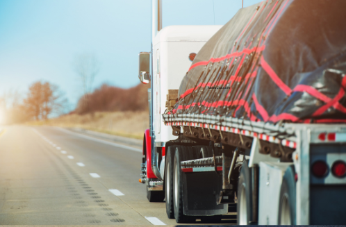 heavy duty trailer with black and red cargo on the road to be repaired and maintenanced