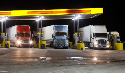 3 trucks at a DOT weight station pumping gas with a yellow roofed station